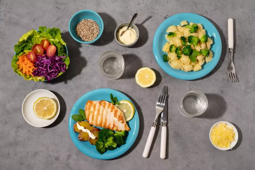A clean, well-lit kitchen counter with a variety of post-operative diet-friendly foods neatly arranged. In the foreground, a plate showcases a balanced meal of grilled chicken, steamed vegetables, and a side of whole grain rice. In the middle ground, various containers hold other recommended items like yogurt, fruits, and nuts. The background features a minimalist, airy space with natural light streaming in through large windows, creating a serene, healing atmosphere. The overall composition emphasizes simplicity, nutrition, and the tranquil environment conducive to post-operative recovery.