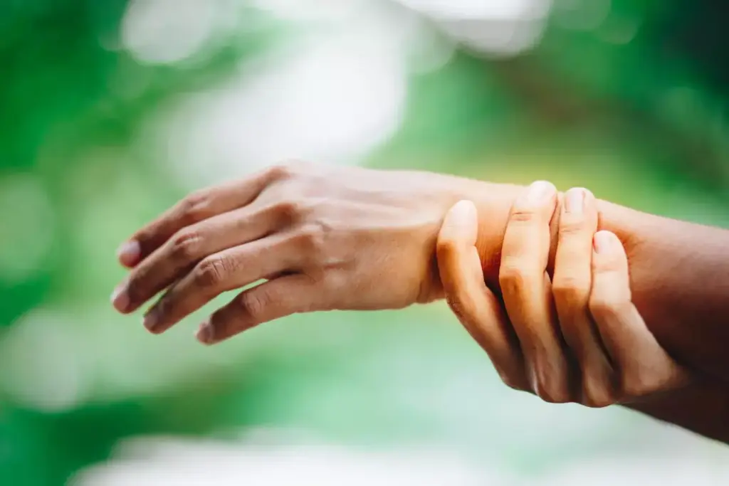 A close-up view of a well-healed carpal tunnel release surgery scar on the palm of a hand. The scar is approximately 2 inches long, with clean, slightly raised edges and a pinkish-red color. The skin around the scar appears smooth and supple, indicating proper healing. The lighting is soft and diffused, casting gentle shadows that accentuate the texture and contours of the scar. The angle is slightly tilted to provide a detailed, three-dimensional perspective of the scar's appearance. The overall mood is clinical yet informative, focusing on the key visual details that would be useful for understanding the typical appearance of a post-surgical carpal tunnel scar.
