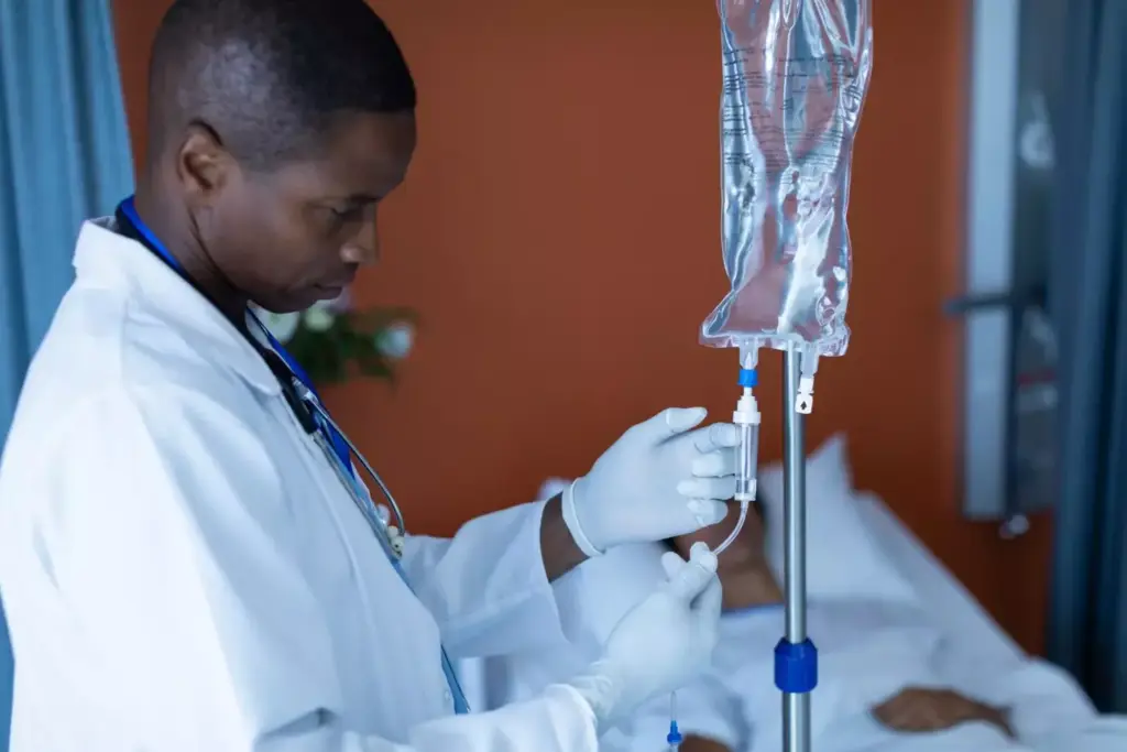A detailed medical illustration showcasing the chemo infusion process. In the foreground, a patient's arm with an IV line connected to a clear fluid-filled bag, the infusion slowly dripping into the vein. The middle ground features a nurse carefully monitoring the infusion, their expression serene and focused. In the background, a clinical hospital setting with medical equipment and a soothing, muted color palette. Bright, diffused lighting casts a gentle glow, conveying a sense of care and professionalism. The scene captures the precise, delicate nature of administering chemotherapy, highlighting the expertise and attentiveness required.