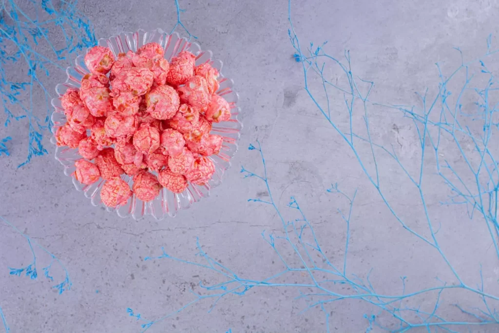 A detailed microscopic view of cancerous acute myeloid leukemia (AML) cells, showcasing their irregular, abnormal shapes and sizes, against a neutral grey background. Bright field lighting illuminates the cells, revealing their intricate nuclear structures and cytoplasmic features. The focal point is on a cluster of malignant myeloid cells, with a depth of field that gently blurs the edges, emphasizing the pathological nature of the disease. The overall mood is one of scientific curiosity and medical understanding, conveying the complexities of this specific type of blood cancer.