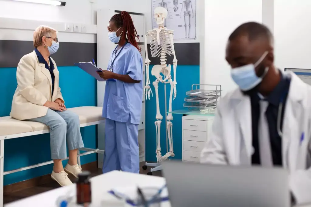 A detailed surgical theater during an ACL reconstruction procedure. In the foreground, the patient's exposed knee joint is surrounded by a team of skilled orthopedic surgeons and nurses, their hands deftly manipulating specialized instruments. Bright surgical lights illuminate the scene, casting a clinical glow. In the middle ground, various medical equipment like arthroscopes, suture materials, and implants are neatly arranged, ready for use. The background shows the sterile environment of the operating room, with clean white walls and floors, conveying a sense of precision and professionalism. The overall atmosphere is one of focused intensity, as the medical team works to meticulously repair the damaged ligament and restore the patient's mobility.