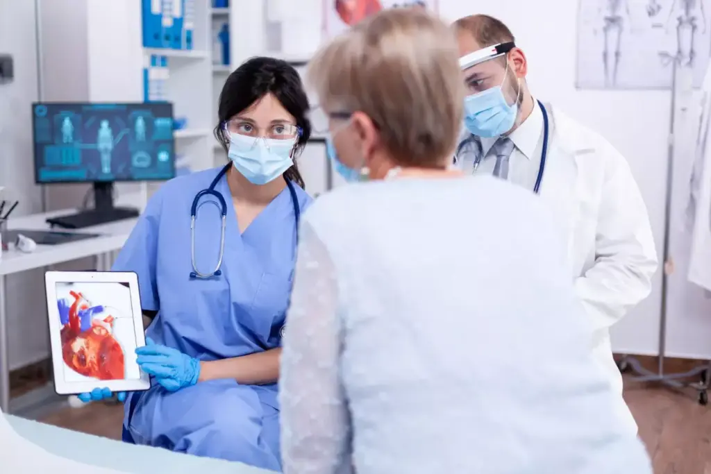 A high-contrast medical scene depicting the emergency response protocol for treating a heart attack. In the foreground, a team of healthcare professionals in scrubs and masks perform CPR on a patient lying on an examination table, surrounded by advanced life support equipment like defibrillators and IV drips. The middle ground shows a 3D anatomical diagram of the heart, with highlighted areas indicating the affected regions. The background is a dimly lit hospital ward, with the warm glow of overhead surgical lamps illuminating the scene. The lighting is dramatic, casting long shadows and creating a palpable sense of urgency. The overall tone conveys the gravity and high-stakes nature of the situation, while maintaining a clinical, professional atmosphere.