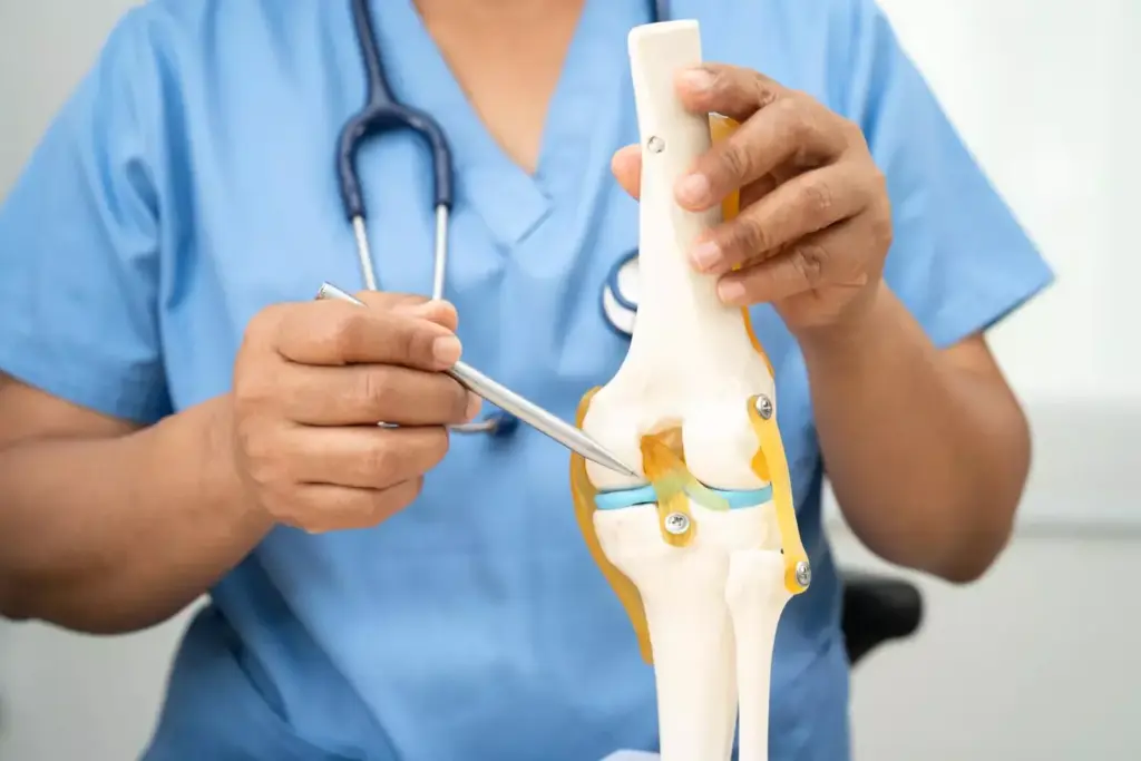A high-resolution, photorealistic image of bone cement being applied during a knee arthroplasty procedure. The foreground shows the surgeon's hands carefully applying the viscous, opaque bone cement into the prepared joint cavity. The middle ground features the patient's exposed knee, with the surgical incision and surrounding soft tissues visible. The background depicts the sterile operating room environment, with medical equipment and lighting fixtures providing a clinical atmosphere. The image conveys the technical precision and scientific nature of this orthopedic procedure, with a focus on the role of bone cement in securing the implant components to the patient's bones.