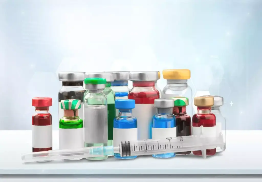 A laboratory counter with an array of pharmaceuticals and medical equipment. In the foreground, a collection of various pill bottles, syringes, and vials of medication, artfully arranged. The middle ground features a stack of medical journals and a computer monitor displaying molecular structures and drug information. The background is softly lit, with a subtle depth of field, conveying a sense of scientific precision and medical expertise. The overall composition suggests the comprehensive nature of myocardial infarction treatments, with a focus on the essential drugs used in this context.