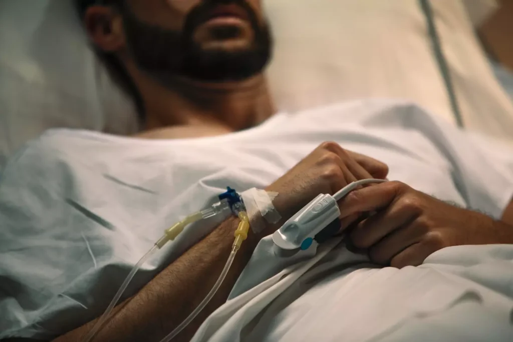 A patient resting comfortably in a hospital bed, recovering from a bone marrow biopsy procedure. The foreground shows the patient's arm bandaged at the site of the biopsy, with a warm compress applied for soothing relief. The middle ground depicts a calming, dimly lit hospital room with soft lighting, creating a peaceful atmosphere. In the background, medical equipment and monitors subtly suggest the clinical setting, while maintaining a sense of tranquility. The overall scene conveys a sense of care, healing, and the patient's gradual recovery from the biopsy.