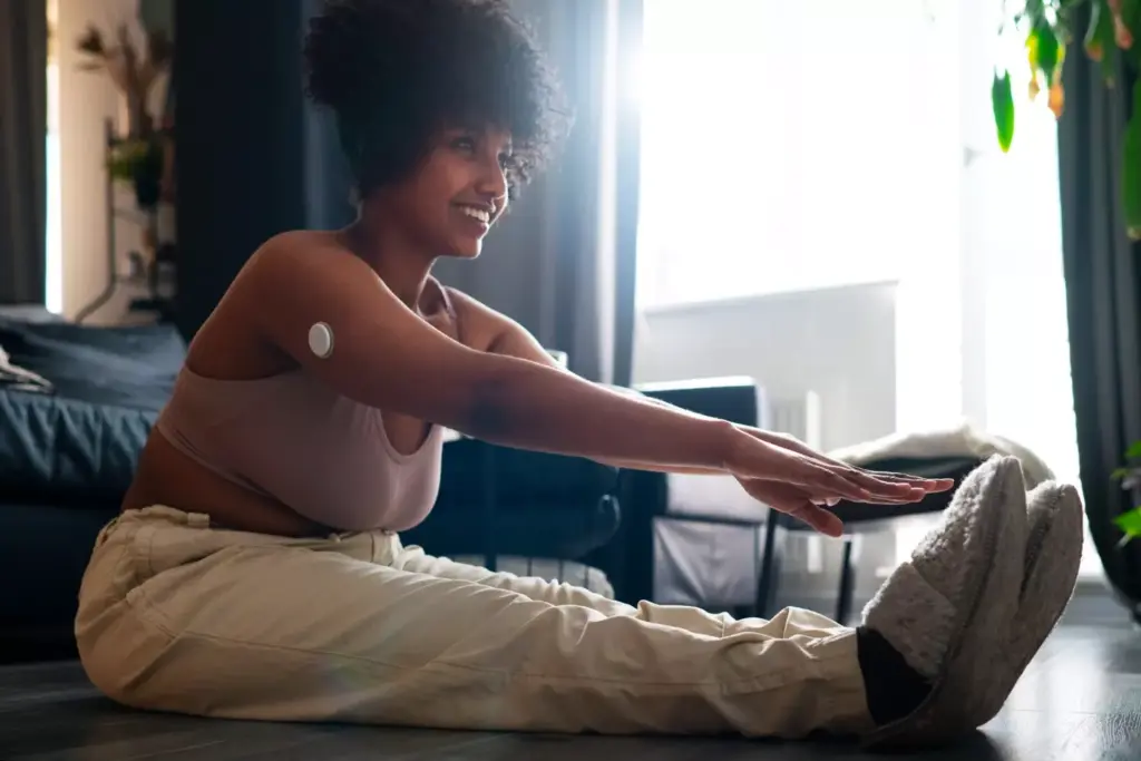 A patient undergoing ACL reconstruction recovery, sitting on a bench in a physical therapy clinic. Sunlight streams through large windows, casting a warm, hopeful glow. The patient examines their knee, wrapped in a supportive brace, as a physical therapist guides them through gentle exercises. The mood is one of determination and optimism, reflecting the gradual progress expected during the rehabilitation process. The image captures the patient's journey, showcasing the care and expertise of the medical professionals supporting their recovery.