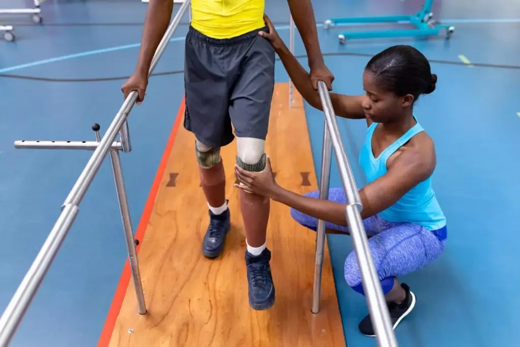 A patient walking confidently with the aid of a cane in a well-lit, modern physical therapy clinic. The patient's leg is wrapped in a medical bandage, indicating a recent knee replacement surgery. In the middle ground, a physiotherapist observes the patient's gait and posture, providing guidance and encouragement. The background features clean, minimalist decor, with large windows allowing natural light to flood the space, creating a calm, therapeutic atmosphere. The overall scene conveys a sense of progress and recovery, reflecting the 6-week milestone after a successful knee replacement procedure.