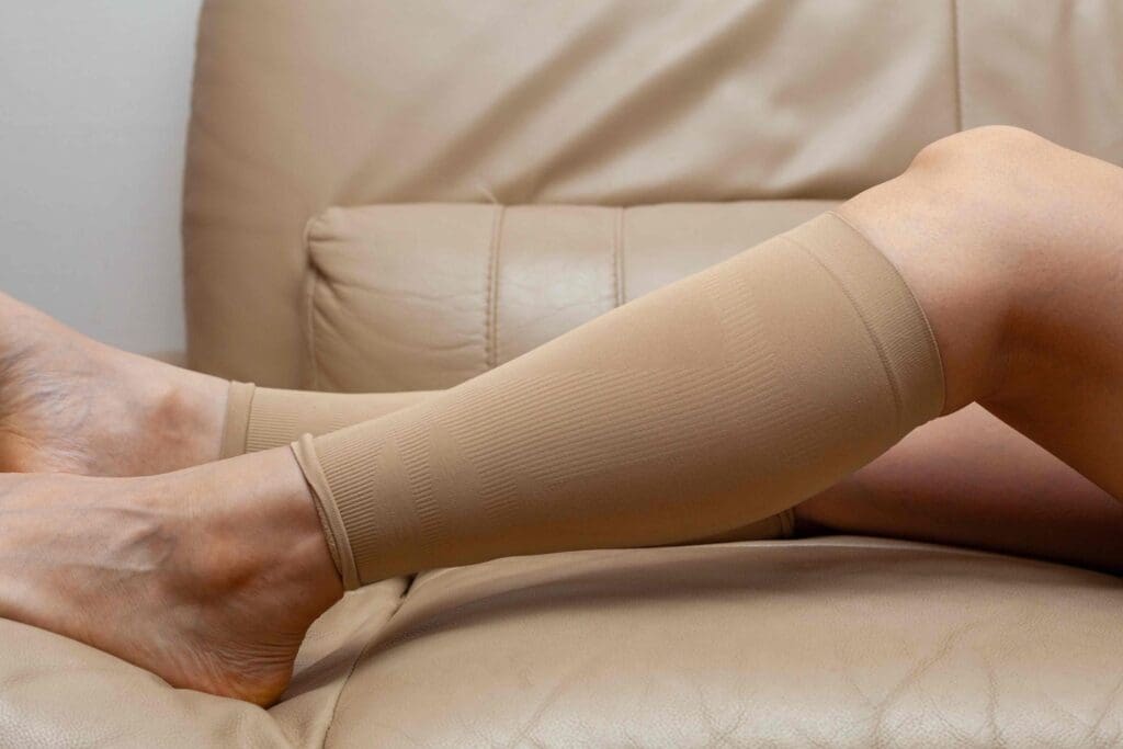 A person's lower legs, clad in compression stockings, resting