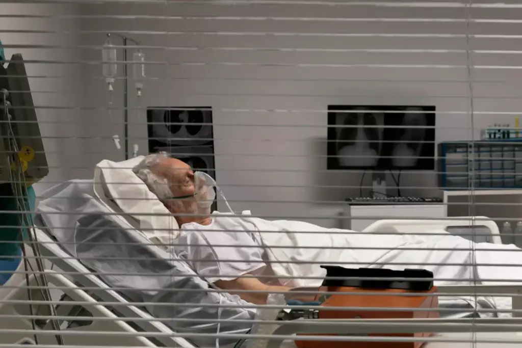 A weary patient rests against a hospital bed, their face etched with fatigue. An IV drip stands tall beside them, a symbol of the chemotherapy treatment coursing through their veins. The room is bathed in a soft, muted light, creating a somber yet intimate atmosphere. In the background, medical equipment and the faint outline of a nurse convey the clinical setting, underscoring the challenges of the cancer journey. The image captures the direct connection between chemotherapy and the profound tiredness it can bring, a poignant representation of the section's focus.