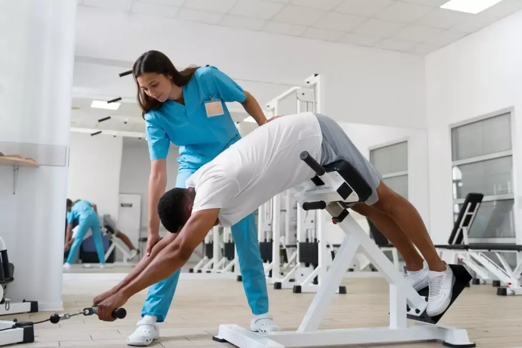A well-lit, clean and organized physical therapy clinic. In the foreground, a massage table and various rehabilitation equipment like exercise balls, resistance bands, and foam rollers. In the middle ground, a patient performing knee exercises under the supervision of a physical therapist. The background features wall-mounted posters and diagrams depicting the anatomy and recovery process of an ACL injury. Warm, natural lighting illuminates the scene, conveying a sense of care, professionalism and a dedicated recovery environment.