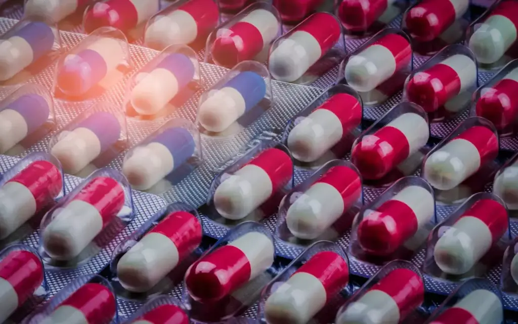 High-resolution, macro close-up photograph of various chemotherapy pills and capsules against a plain, soft-focus background. The pills are arranged in a neat, organized pattern, filling the frame. The pills should appear slightly blurred, with a shallow depth of field to emphasize their detailed, textured surfaces. Soft, directional lighting from the side creates gentle shadows and highlights the pharmaceutical nature of the subject. The overall mood is clinical, scientific, and contemplative, reflecting the complex nature of brain cancer treatment.