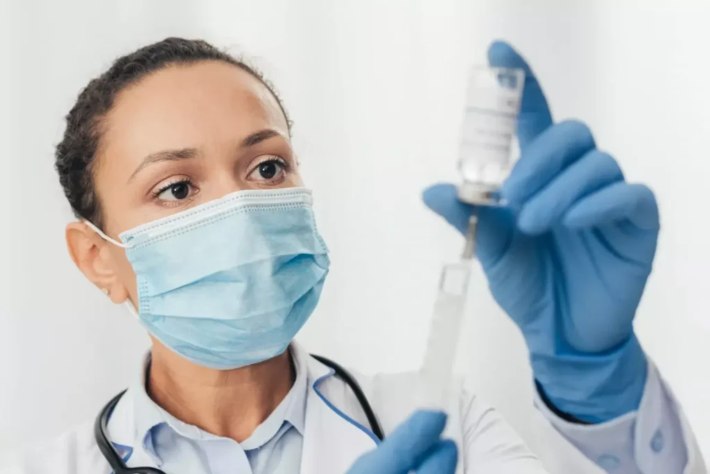 a doctor in a white coat is carefully preparing a syringe, their expression focused and professional a doctor in a white coat is carefully preparing a syringe, their expression focused and professional