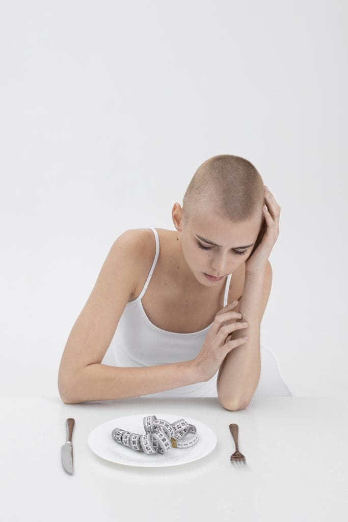 young woman with eating disorder having tape measure plate LIV Hospital